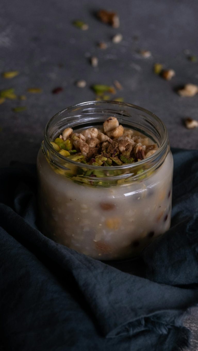 A cozy jar of homemade oatmeal with nuts and dried fruits on a dark surface.