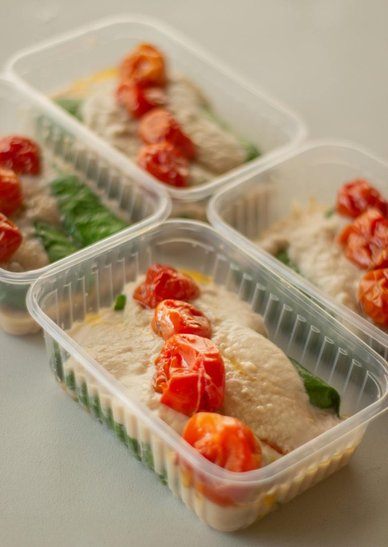 Close-up of healthy meal prep with cherry tomatoes in plastic containers.